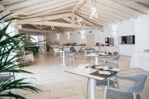 - un restaurant avec des tables et des chaises dans une salle dans l'établissement Piccolo Hotel - Adults Only, à Porto Ottiolu