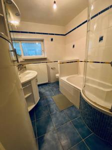 a bathroom with a tub and a toilet and a sink at Schöne Ferienwohnung mit Waldblick in Dillenburg in Dillenburg