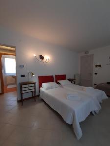 1 dormitorio con 1 cama blanca grande y cabecero rojo en Casa di Clara, en Portogruaro