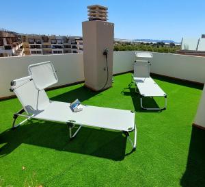 dwa fotele i stół na dachu w obiekcie Ático de ensueño, El Toyo, Almería - Playas, Golf, Cabo de Gata w mieście Retamar