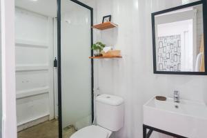 a bathroom with a toilet and a sink and a mirror at Container Smart Stay CSS in Bedugul