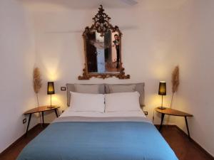 ナポリにあるHistorical Naples with panoramic terraceのベッドルーム1室(鏡とランプ2つ付)