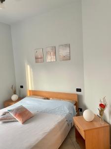 a bedroom with a bed and a wooden headboard at Appartamento ' Il sole di Vale' in Loano +14 photos