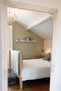 1 dormitorio con cama y espejo en Samen Delen, en Waarland