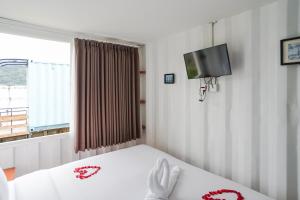 a bedroom with a bed and a tv and a window at Container Smart Stay CSS in Bedugul