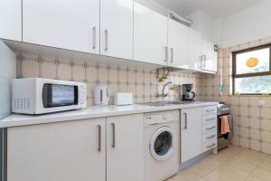 カルヴォエイロにあるApartment Farolのキッチン(電子レンジ、洗濯機、乾燥機付)