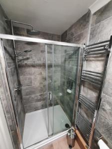 una doccia con porta in vetro in bagno di Highlander House B&B a Rothesay