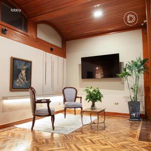 a living room with two chairs and a flat screen tv at Dorado Hotel Boutique - Tacna in Tacna