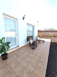 eine Terrasse mit 2 Stühlen, einem Tisch und Fenstern in der Unterkunft Casa Bermeja - Tiscamanita in Tiscamanita