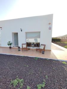 ein weißes Gebäude mit einer Terrasse mit einem Tisch und Stühlen in der Unterkunft Casa Bermeja - Tiscamanita in Tiscamanita