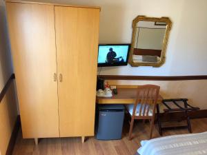 a bedroom with a desk and a cabinet and a mirror at Hotel Signa in Perugia