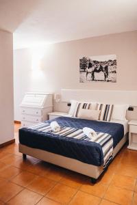 a bedroom with a bed and a picture of horses at Amareclub Le Rose in San Teodoro