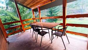einen Tisch und Stühle auf einer abgeschirmten Veranda in der Unterkunft Vikendica Boki i Maki in Divčibare
