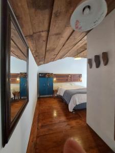 - une chambre avec un lit et un grand miroir dans l'établissement Cozy Bohemian Loft Apartment close Central Plaza, à Antigua Guatemala