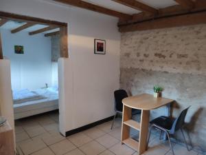 a small table and chairs in a room with a bed at la mini ferme de maëlou in Sermaises