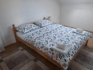 - un lit avec des draps et des oreillers bleus et blancs dans l'établissement Apartman Zoran, à Livno
