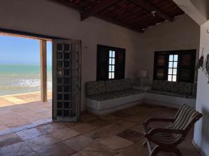 a room with a couch and a chair and the ocean at Beach Place Fontainha in Aracati