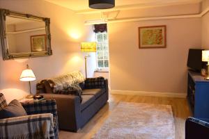 a living room with a couch and a mirror at Linnhe Apartment, Kinlochlaich House in Appin