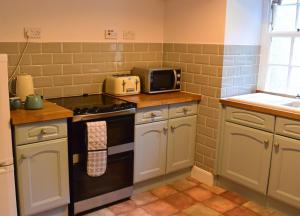 a kitchen with a stove and a microwave at Linnhe in Appin