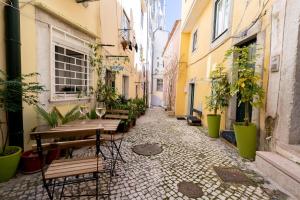 an alley with tables and chairs in an alley at Alfama Nest in Lisbon