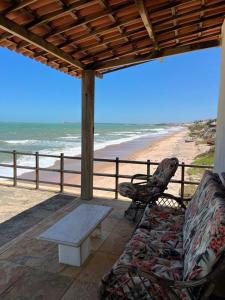 a porch with a couch and a table and the beach at Beach Place Fontainha in Aracati