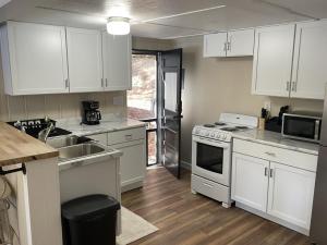 una cocina con armarios blancos y fregadero en Lakeshore Fishing cabin 1 , dock/boat slip, fire pit., en Lake Ozark