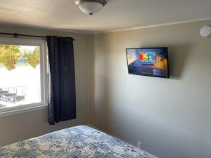 a bedroom with a tv on the wall and a bed at Lakeshore Fishing cabin 1 , dock/boat slip, fire pit. in Lake Ozark