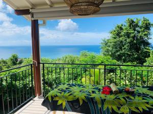 un balcone con tavolo e vista sull'oceano di Magnifique Villa Bauhinia, Piscine vue mer a Sainte-Luce