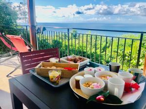 サント・リュスにあるMagnifique Villa Bauhinia, Piscine vue merのバルコニーにテーブルと食料品のトレイ