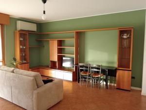 un soggiorno con divano, tavolo e sedie di Casa Sud vicino a fiera e Pordenone centro a Pordenone