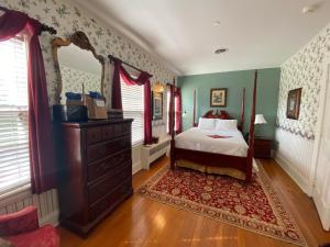 1 dormitorio con cama, tocador y espejo en Historic Rosemont Manor, en Berryville