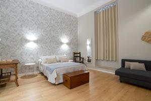 a bedroom with a bed and a table and a couch at Room24 R in Bari