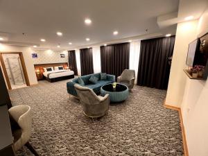 El Emin İstanbul Hotel في إسطنبول: غرفة في الفندق مع أريكة وكراسي وسرير