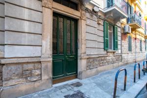 a building with green doors on a street at Room24 R in Bari