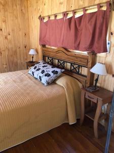 Un dormitorio con una cama y dos lámparas y una ventana. en Marados y Marauno, en Tigre