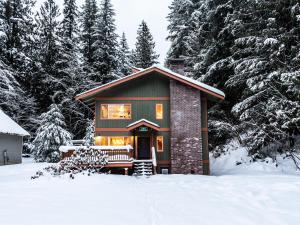 una pequeña casa en la nieve con árboles en Silver Peak Lodge, en Glacier