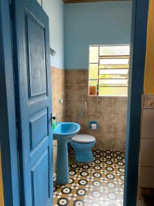 Casa estilo colonial, no Centro de Aiuruoca-MG. في أيوريوكا: حمام مع مرحاض وباب أزرق