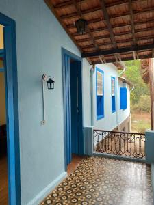 un corridoio con porta blu e balcone di Casa estilo colonial, no Centro de Aiuruoca-MG. a Aiuruoca