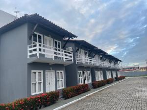 ein Gebäude mit weißen Balkonen und Blumen auf der Straße in der Unterkunft Apartamento no Taperapuan Duplex in Porto Seguro