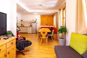 een woonkamer met een tafel en een keuken bij das Cityhouse in Mayrhofen