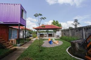 un patio trasero con cenador y parque infantil en Container Smart Stay CSS en Bedugul