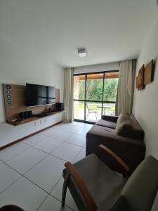 sypialnia z łóżkiem, telewizorem i krzesłem w obiekcie ILOA Condomínio Resort Barra de São Miguel, Próximo a PISCINA bloco L w mieście Barra de São Miguel
