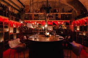 - un bar avec une table dans une pièce dotée de lumières rouges dans l'établissement Ott's Hotel Weinwirtschaft & Biergarten Weil am Rhein/Basel, à Weil am Rhein