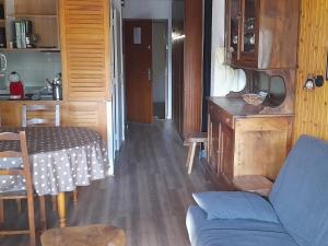 a living room with a blue couch and a table at Appartement La Clusaz, 2 pièces, 6 personnes - FR-1-459-83 in La Clusaz