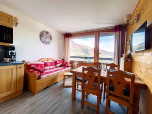 a living room with a couch and a table at Appartement rénové Au pied des pistes Balcon ouest - FR-1-344-769 in Les Menuires