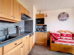a kitchen with a sink and a couch in it at Appartement rénové Au pied des pistes Balcon ouest - FR-1-344-769 in Les Menuires
