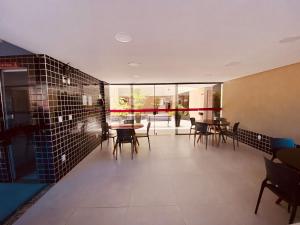 un ristorante con tavoli, sedie e pareti in vetro di Edifício Ramage Apto 115 ER Hospedagens a Maceió