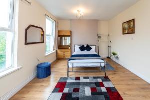 ein Schlafzimmer mit einem Bett und einem Teppich auf einem Holzboden in der Unterkunft Oak Room in Liverpool