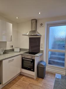 a kitchen with a stove top oven next to a window at Cosy Nite B&B in Birmingham