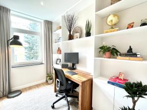 een thuiskantoor met een bureau en een computer bij New stylish 1 bedroom apt w/ 2 balconies in Centrum in Amsterdam